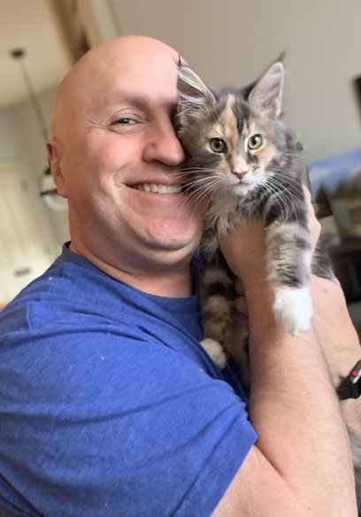 A man holding a cat in his arms.