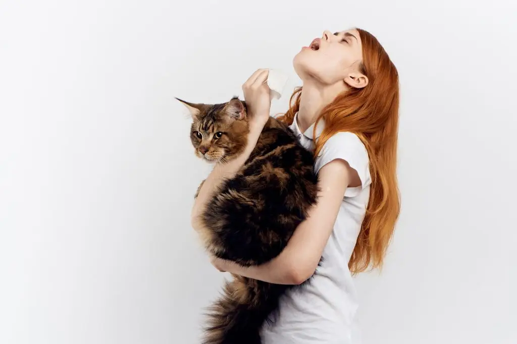 A woman holding a cat in her arms.