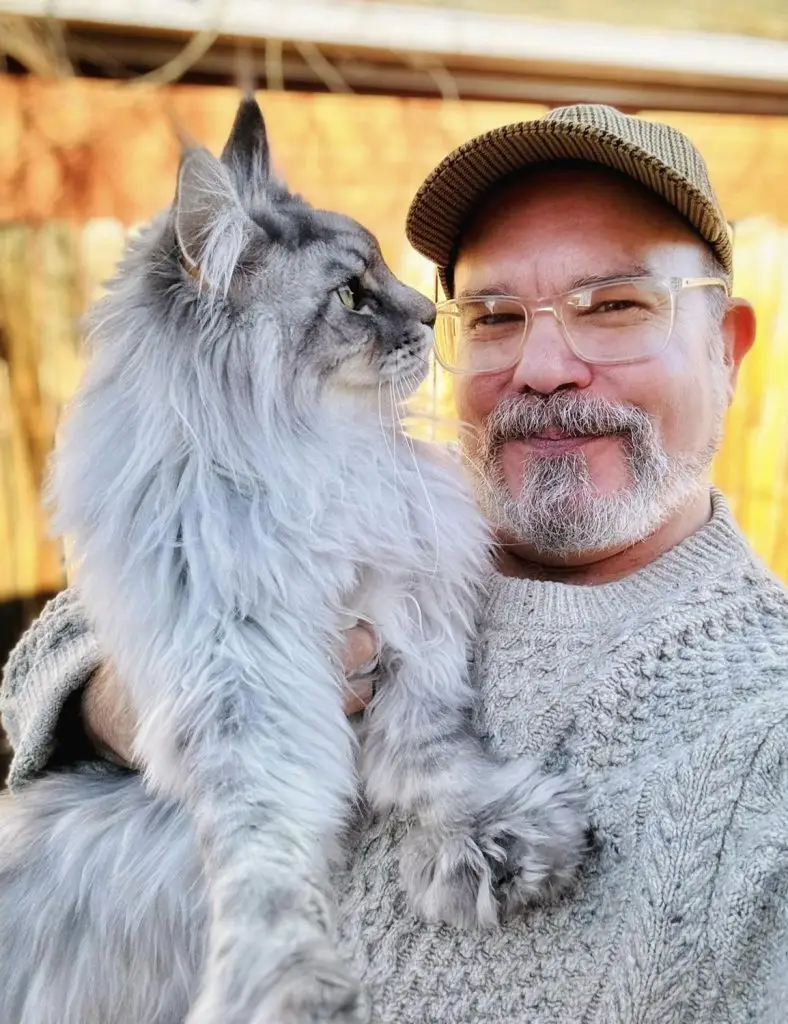 A man holding a cat in his arms.